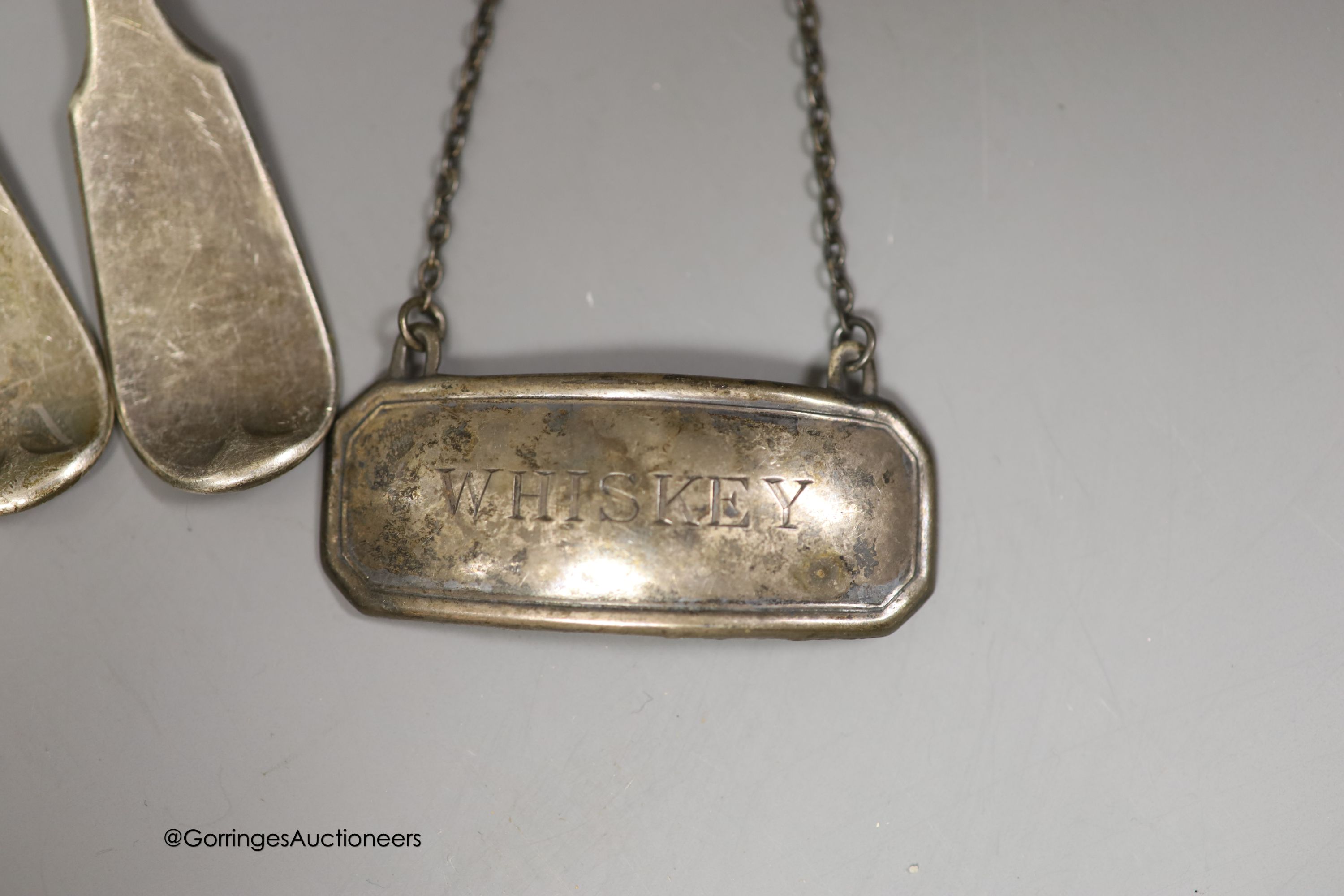 Nine items of assorted 19th century and later silver flatware and a silver 'Whiskey' wine label, 9.5oz.